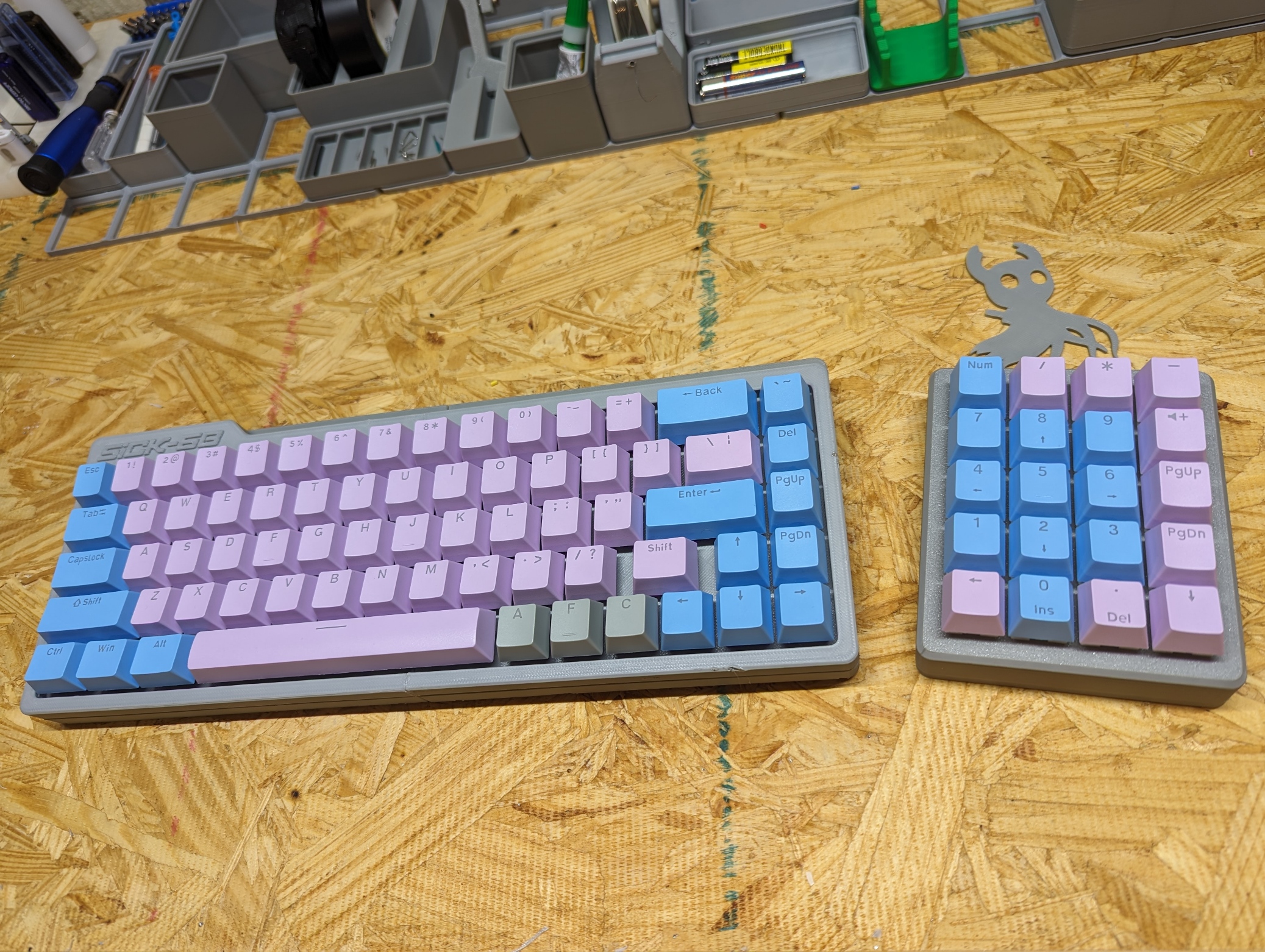 Picture of a grey sick68 3d printed keyboard with blue and pink O E M keycaps.